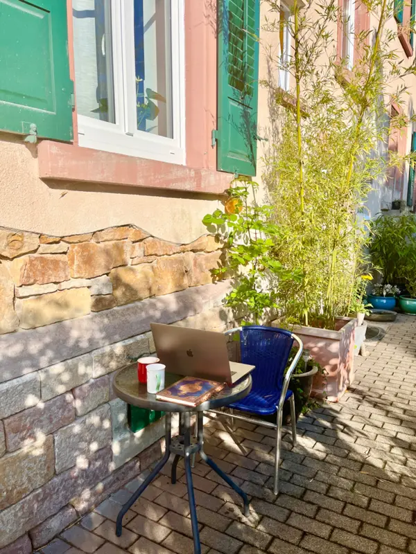 Kleiner Tisch mit Stuhl im Hof neben der Sandsteinmauer
