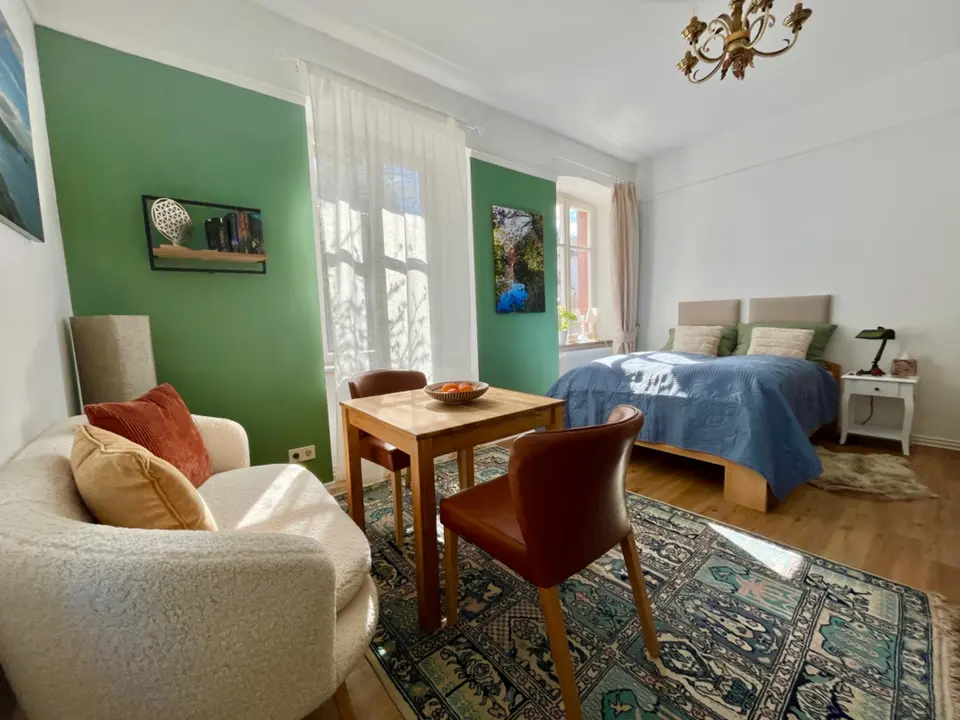 Appartement Zaubernuss mit Doppelbett, Esstisch, Sessel und grüner Wand